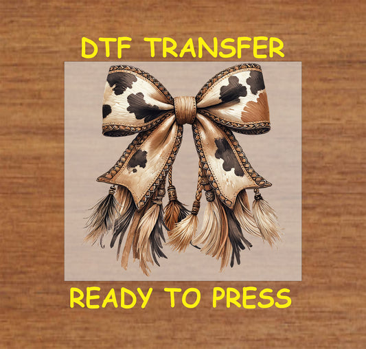 Cow print bow with rope details, stitched edges, and tassel fringe.