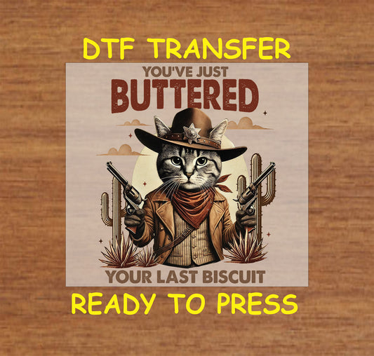 Western DTF transfer with a cowboy cat in a sheriff hat, dual pistols, and desert background.