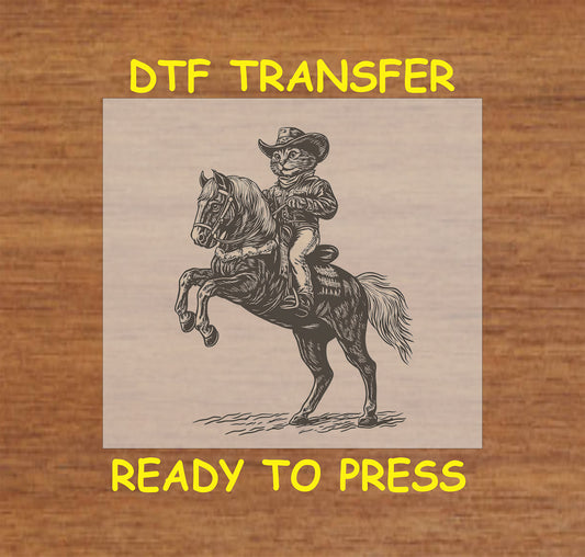 Cowboy cat DTF transfer featuring a cat in a cowboy outfit riding a rearing horse.