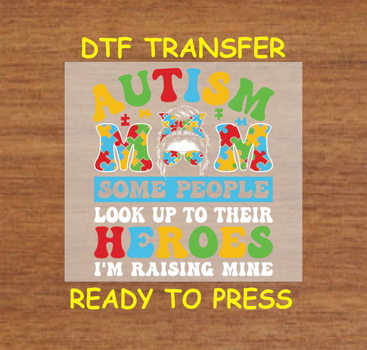 Autism mom messy bun with puzzle bow and “I’m raising mine” quote in bold colors.