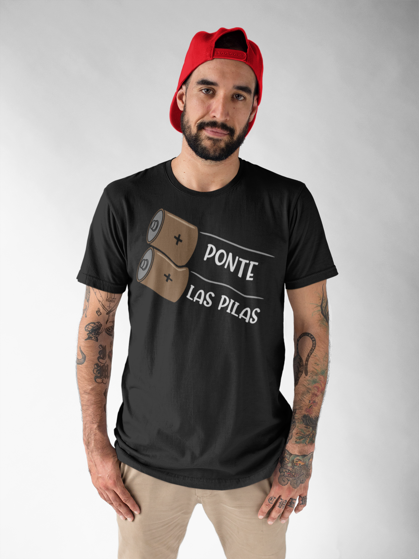 Close-up of a black "Ponte Las Pilas" T-shirt, showcasing the detailed battery design and Spanish motivational phrase.