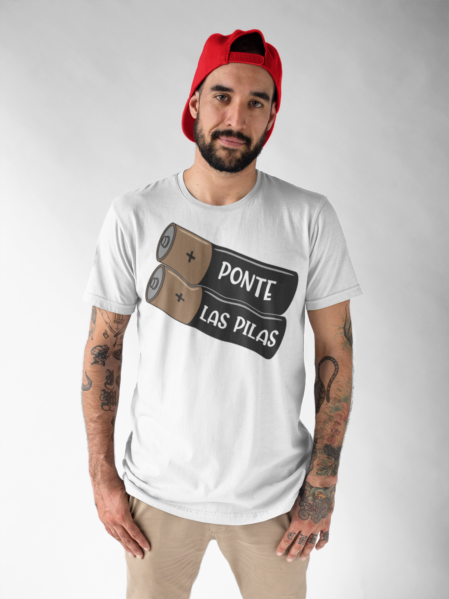 Man wearing a black "Ponte Las Pilas" T-shirt with a battery design, conveying a motivational message in Spanish.