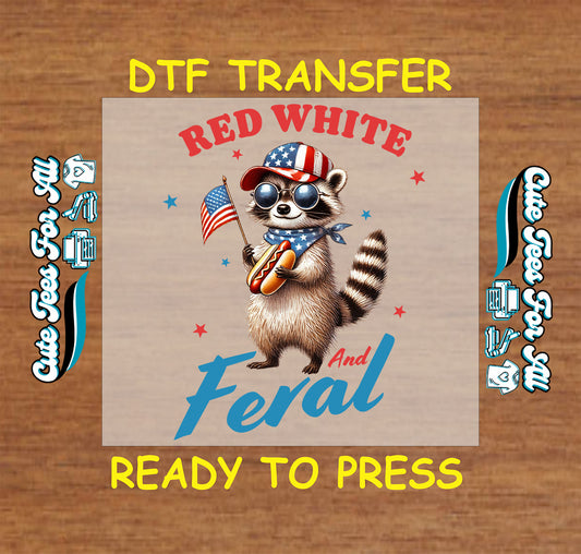 Patriotic DTF transfer with raccoon wearing USA gear, holding hotdog and flag with "Red White and Feral" text.