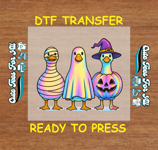 Three cartoon ducks dressed as a mummy, ghost, and pumpkin witch in Halloween DTF transfer