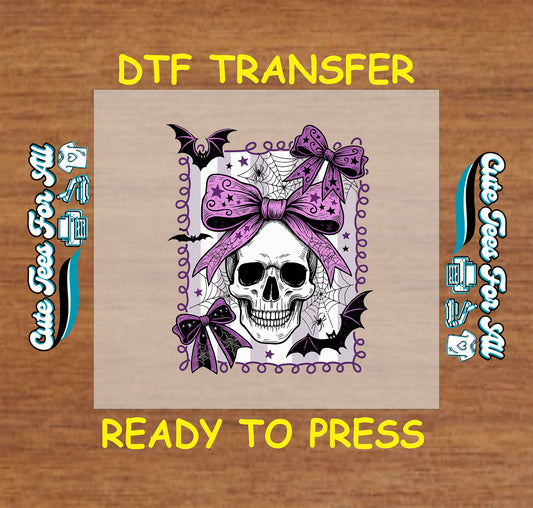 Skull with pink bows, bats, and spiderwebs framed in purple on Halloween DTF transfer

