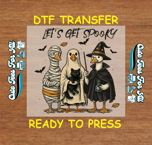 Duck trio dressed as mummy, ghost with black cat, and witch with potion under “Let’s Get Spooky” text

