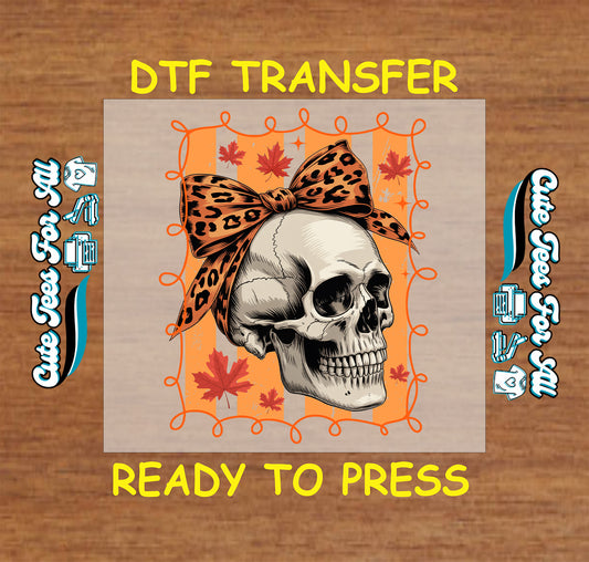 Skull with leopard print bow surrounded by orange maple leaves and orange swirl frame


