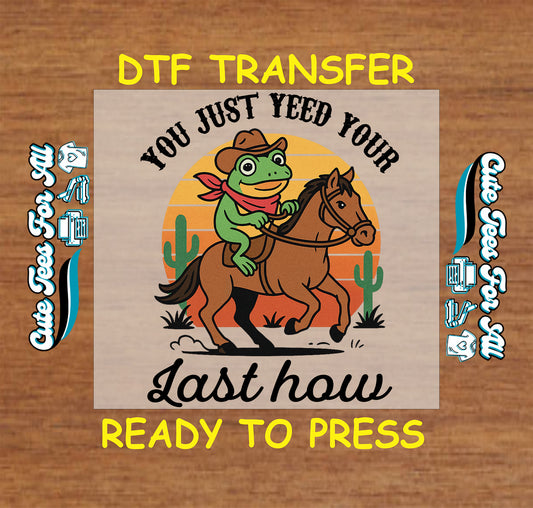 ready to press dtf with cowboy frog on horse, western sunset background, funny yeehaw quote

