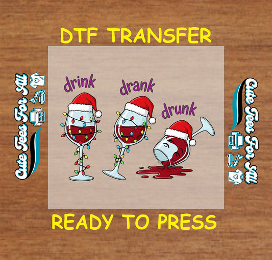 Christmas ready to press DTF transfer with wine glasses in Santa hats, Christmas lights, and the words Drink Drank Drunk.