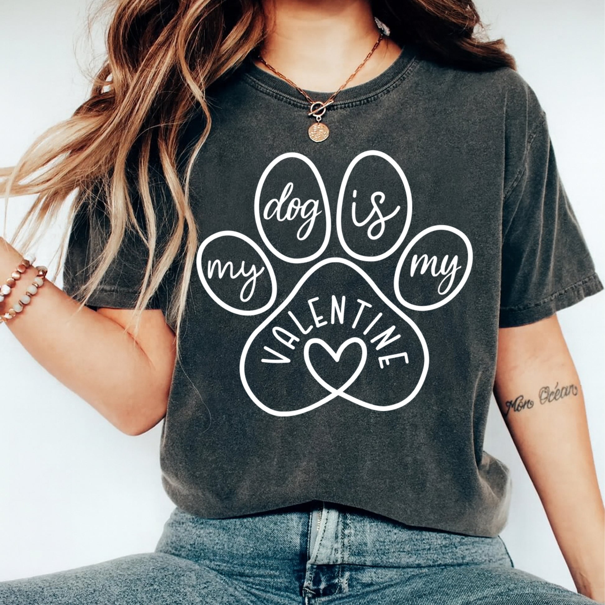 Person wearing a dark gray t-shirt with a paw print design and text.