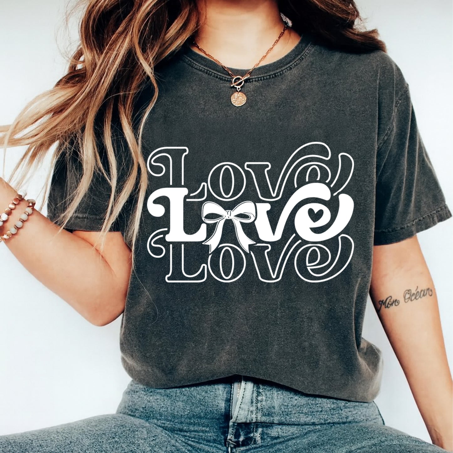 Person wearing a dark gray t-shirt with 'LOVE' text design on a plain background
