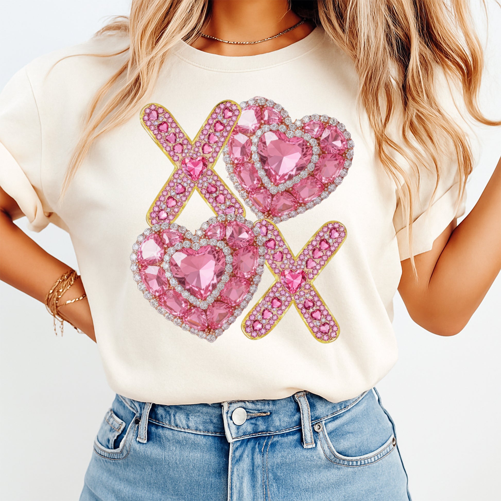 Person wearing a white t-shirt with pink heart designs and 'XOXO' text.
