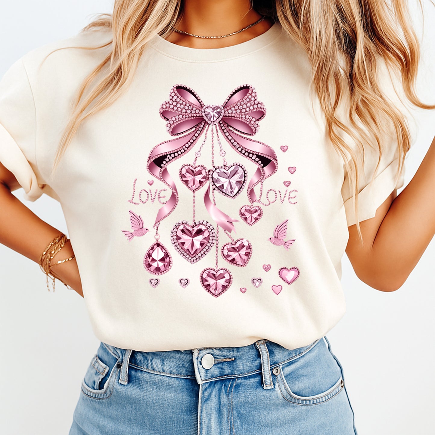 woman wearing cream shirt with pink valentine bow ready to press dtf transfer featuring hanging heart charms rhinestone style hearts and love lettering