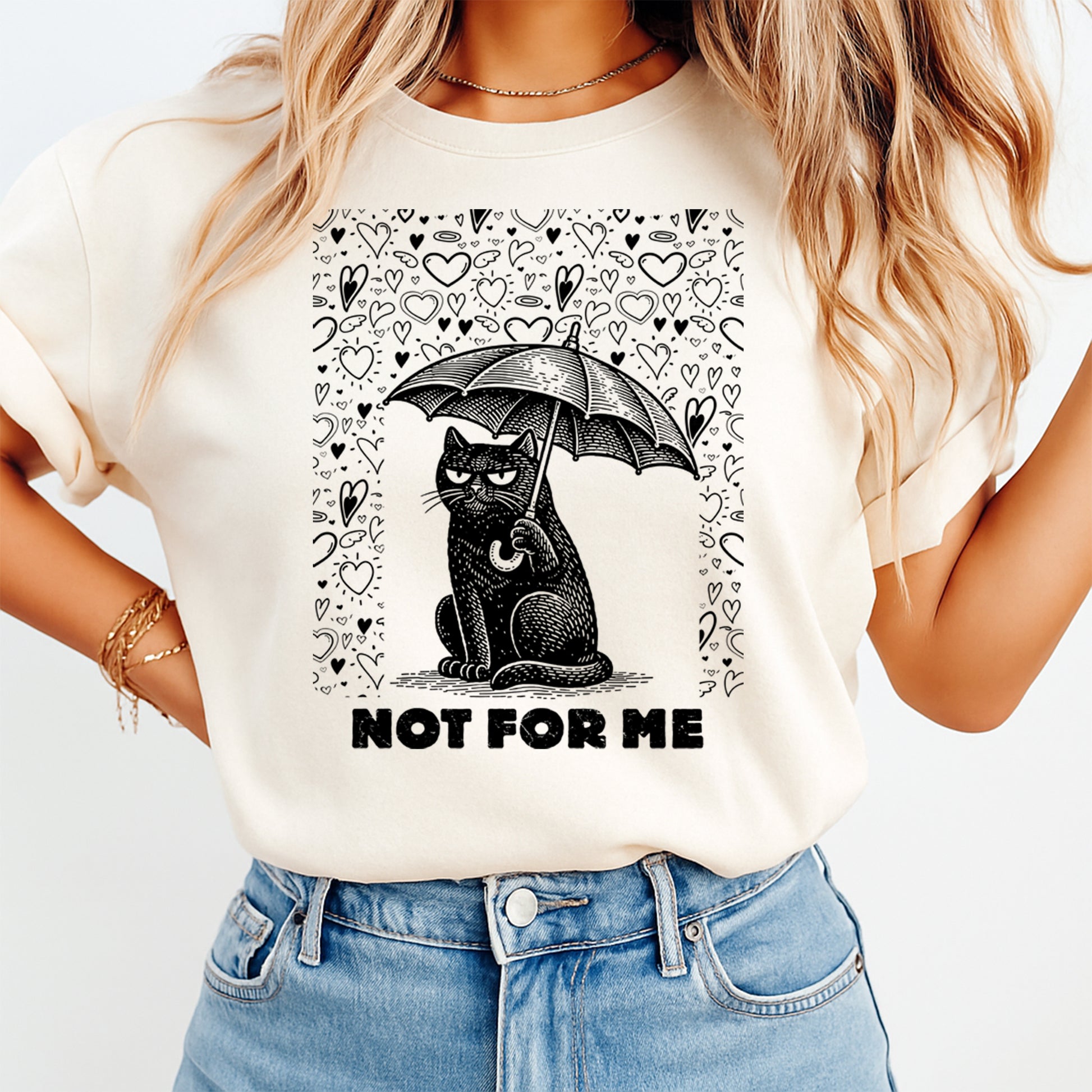 Cream t shirt mockup showing a grumpy black cat holding an umbrella surrounded by hearts with the text Not For Me, sarcastic Valentine graphic tee