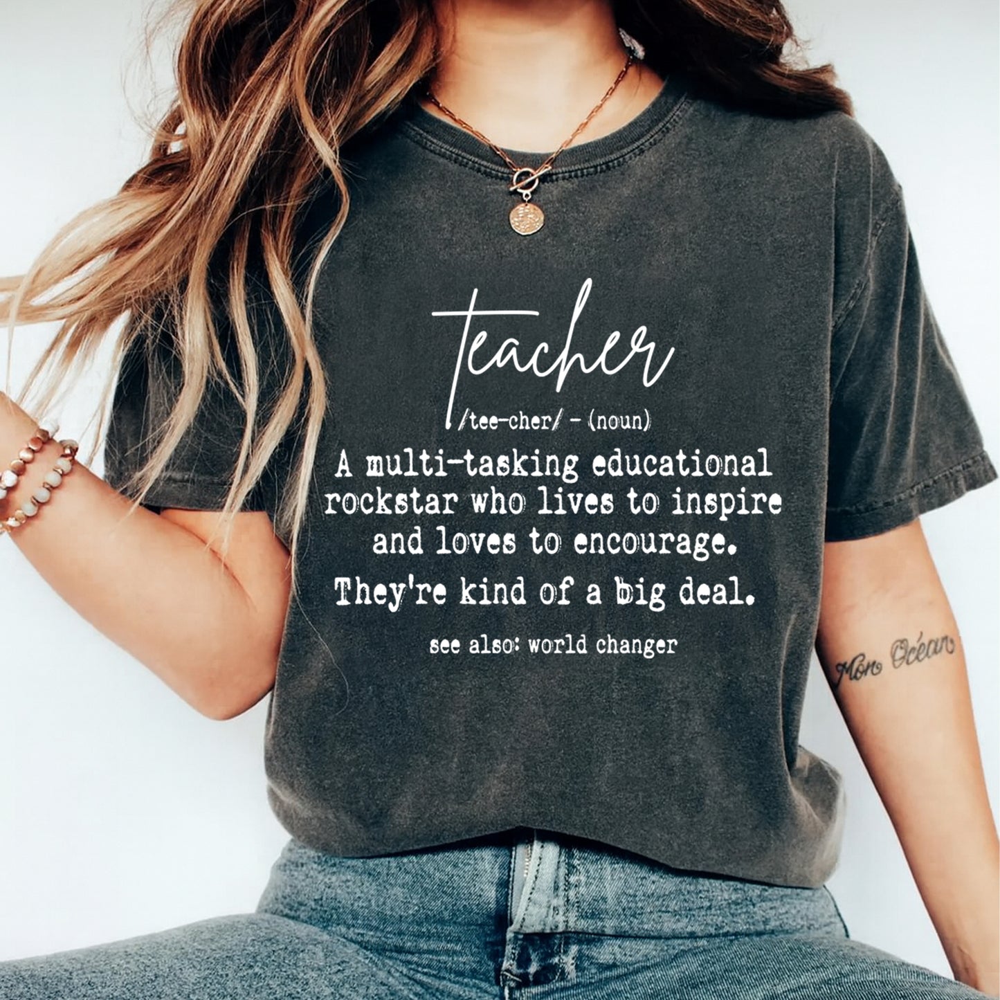 Dark gray t shirt mockup showing teacher definition quote in white lettering, inspirational teacher graphic tee