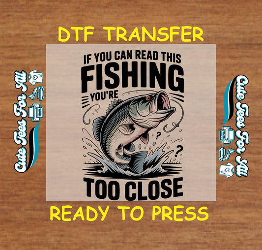 Ready to press dtf transfer artwork featuring if you can read this fishing you’re too close text with jumping bass fish and splash graphic for diy shirts.