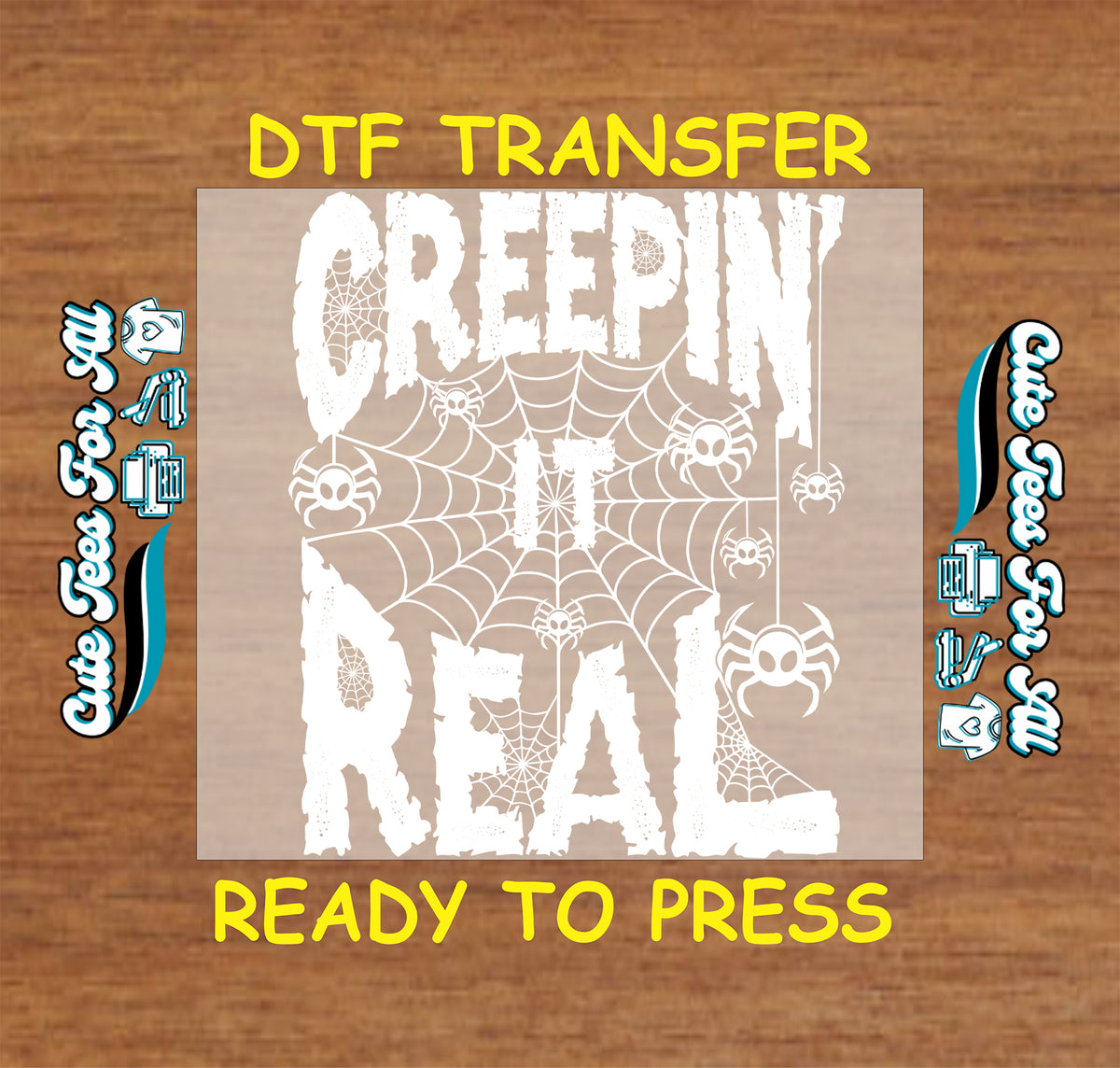 A DTF transfer design preview featuring the phrase 'CREEPIN IT REAL' in distressed white lettering over a spiderweb pattern, shown on a tan rectangular transfer sheet against a wood background with yellow text reading 'DTF TRANSFER' and 'READY TO PRESS'.