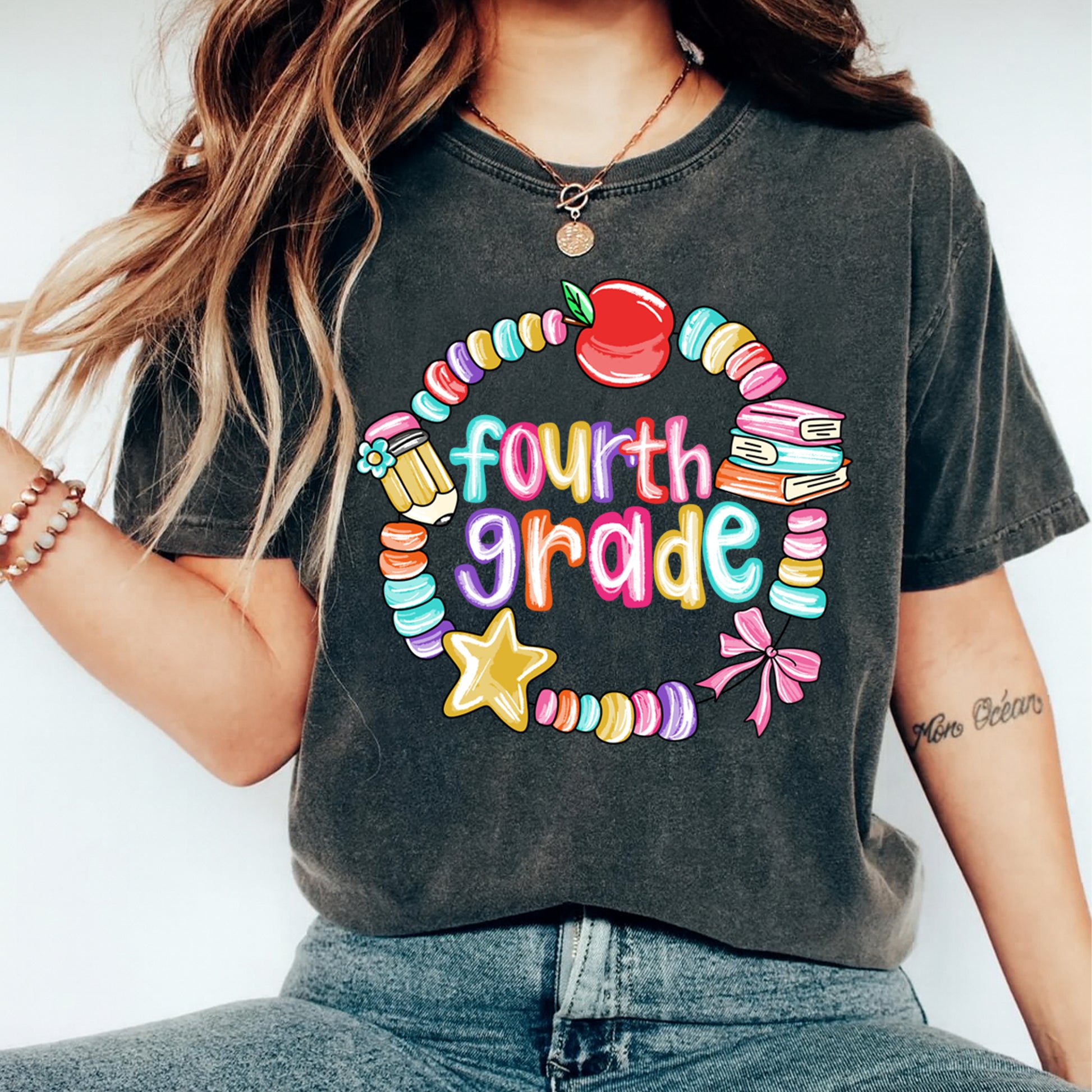 Fourth grade teacher shirt mockup showing colorful apple and book school graphic pressed on dark gray t shirt