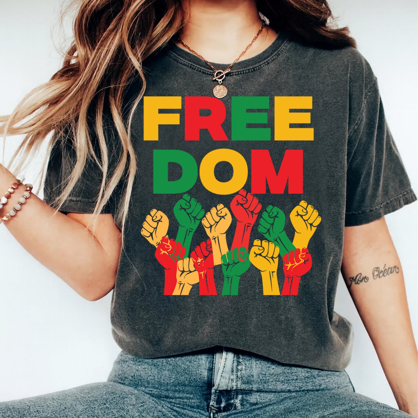 Juneteenth freedom raised fists design shown on dark t shirt mockup with bold red black green unity artwork