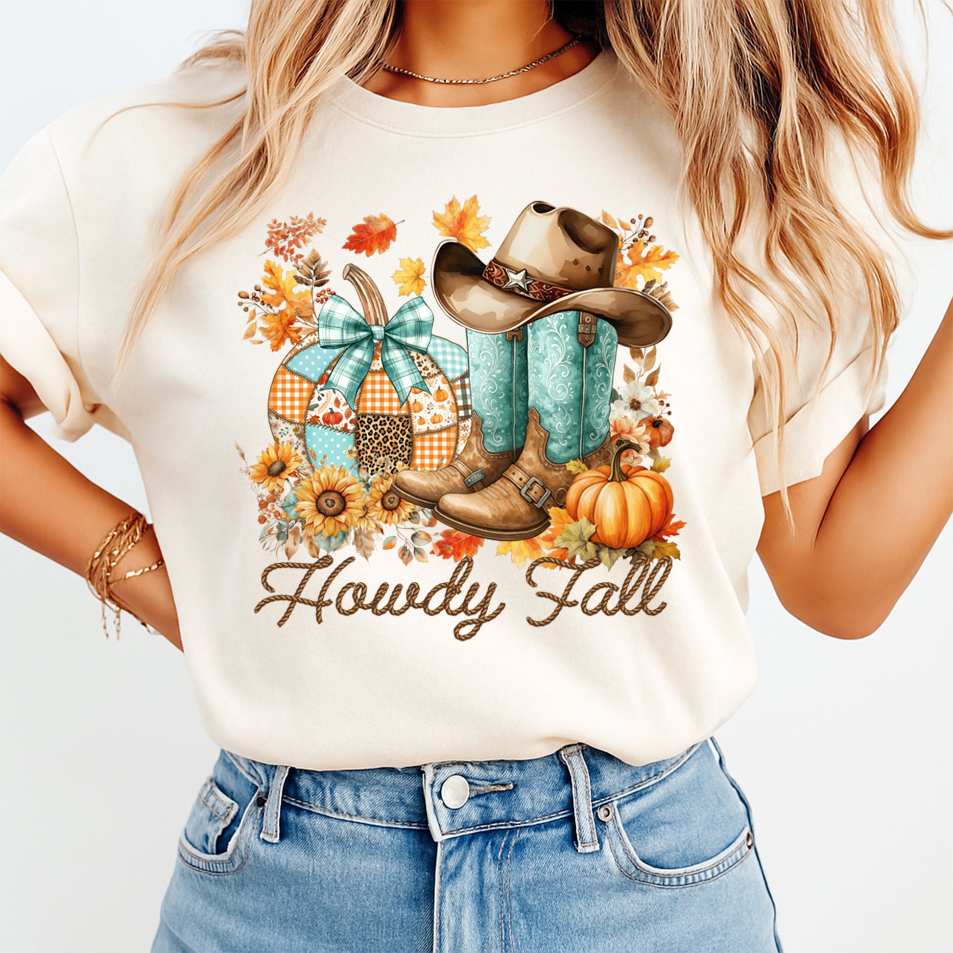 Howdy Fall western boots and pumpkin patch graphic pressed on a cream t shirt showing fall leaves sunflowers and cowgirl style artwork