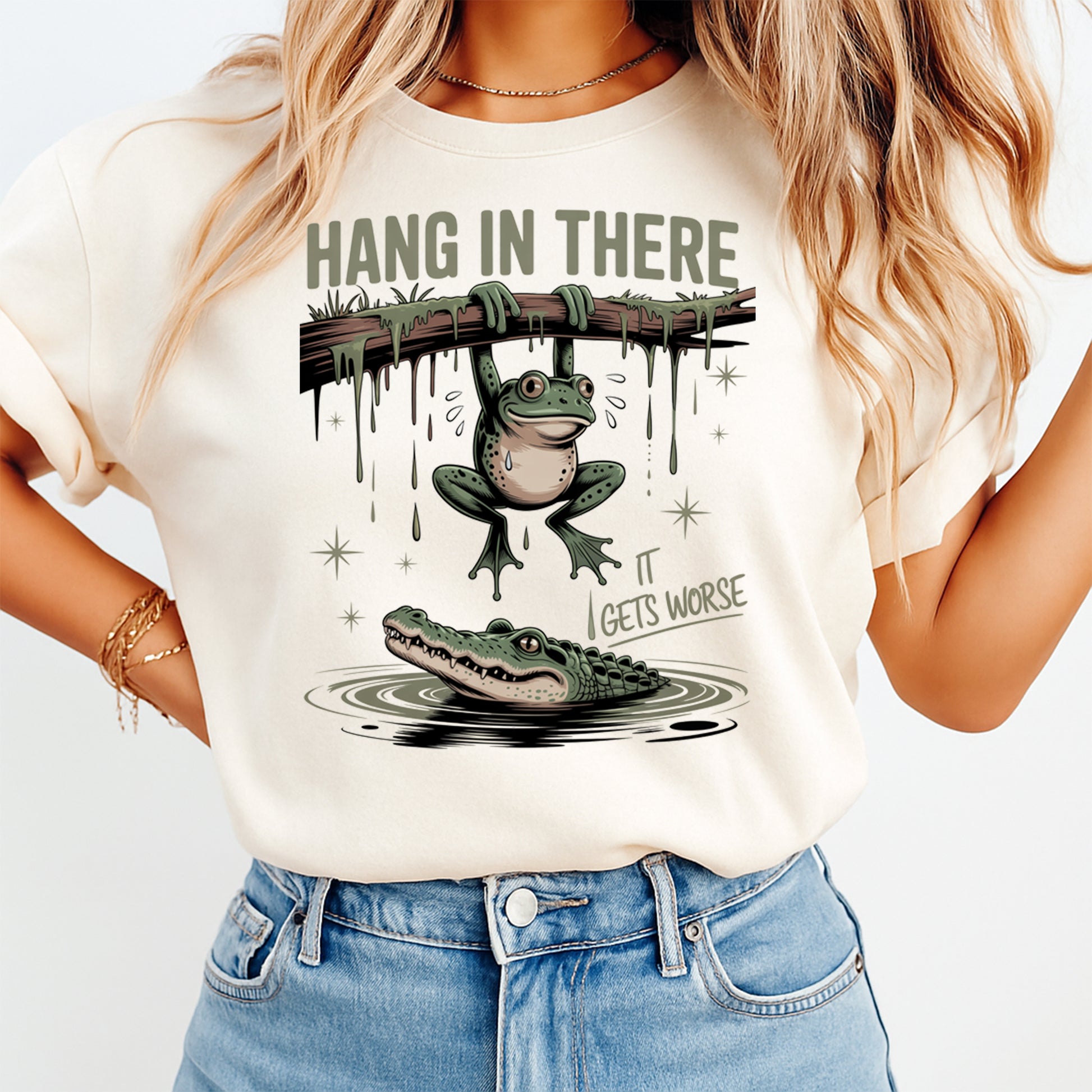 Woman wearing hang in there it gets worse frog graphic shirt with swamp alligator illustration