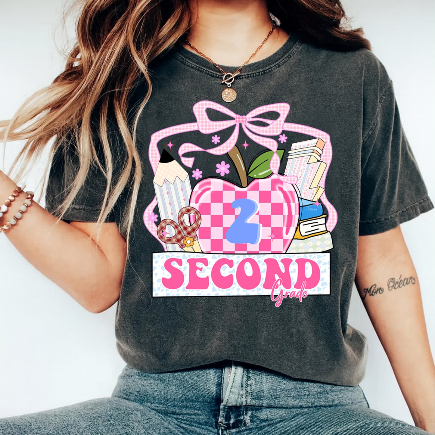 Person wearing a t-shirt with a '2 Second Grade' design on a plain background