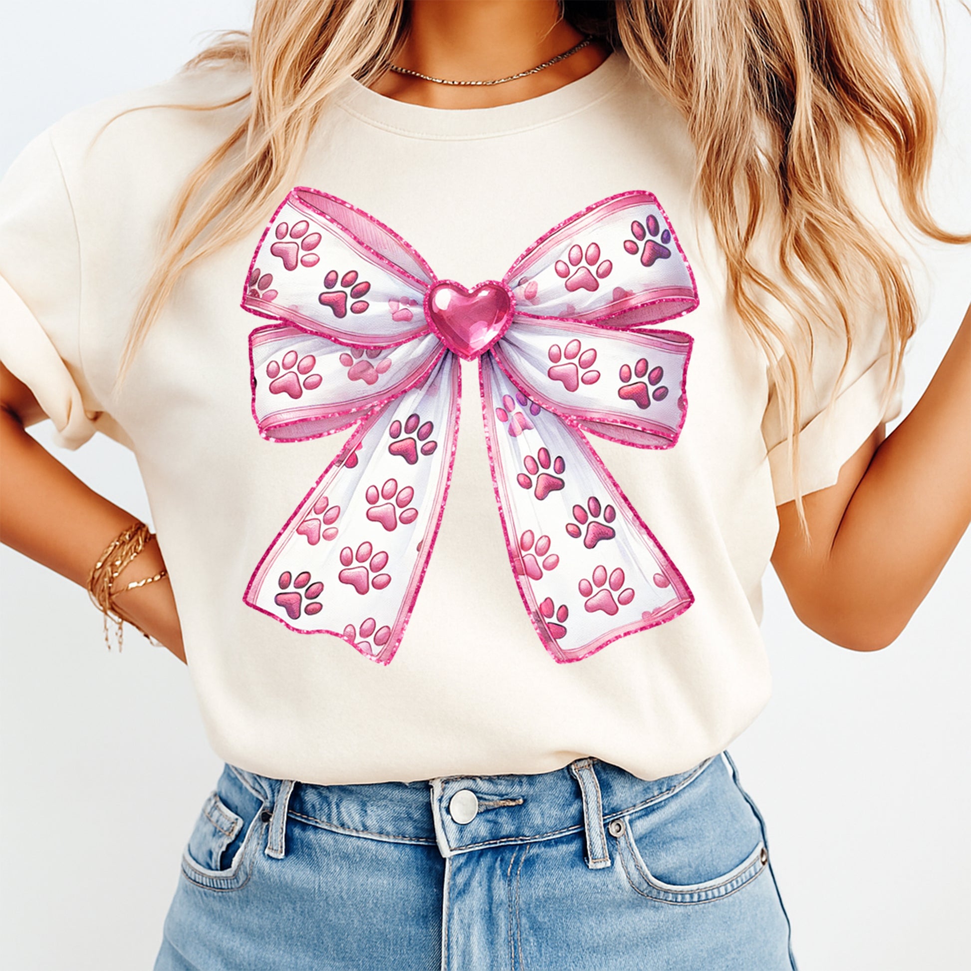 White and pink paw print ribbon bow graphic printed on cream shirt with heart center detail