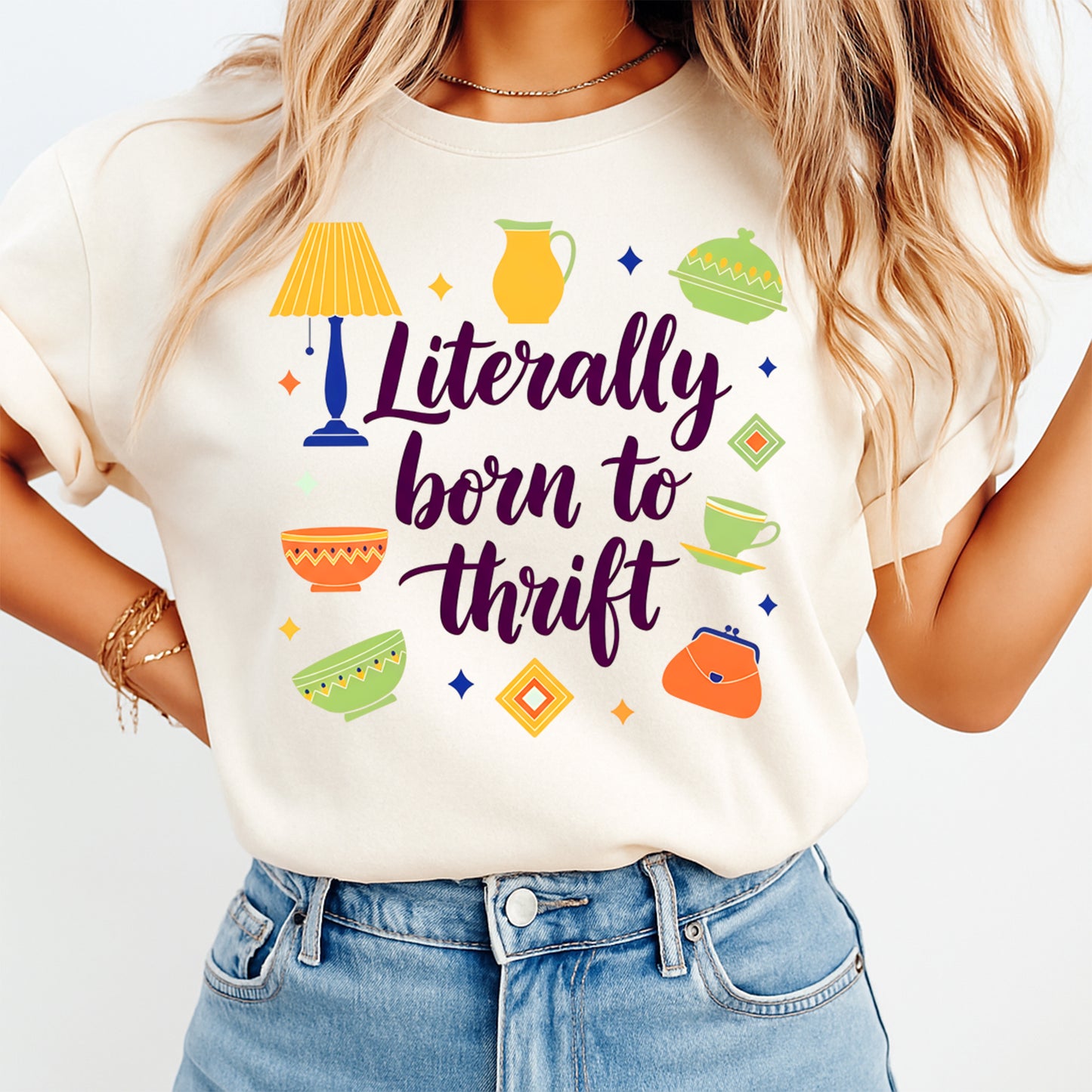 Person wearing a white t-shirt with colorful graphics and text 'Literally born to thrift' on a plain background