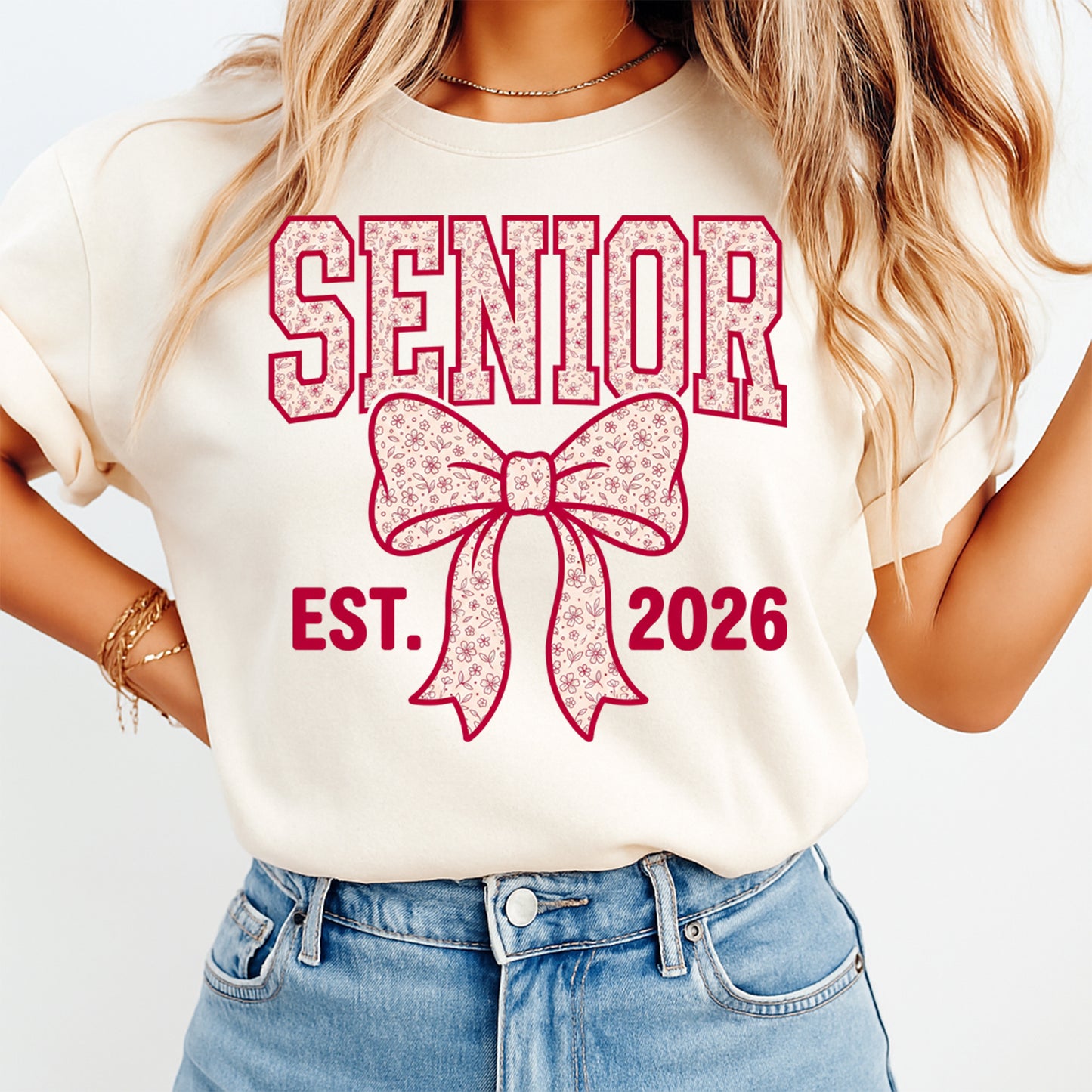 Woman wearing a cream shirt with senior est 2026 floral bow ready to press dtf graphic in pink varsity style lettering
