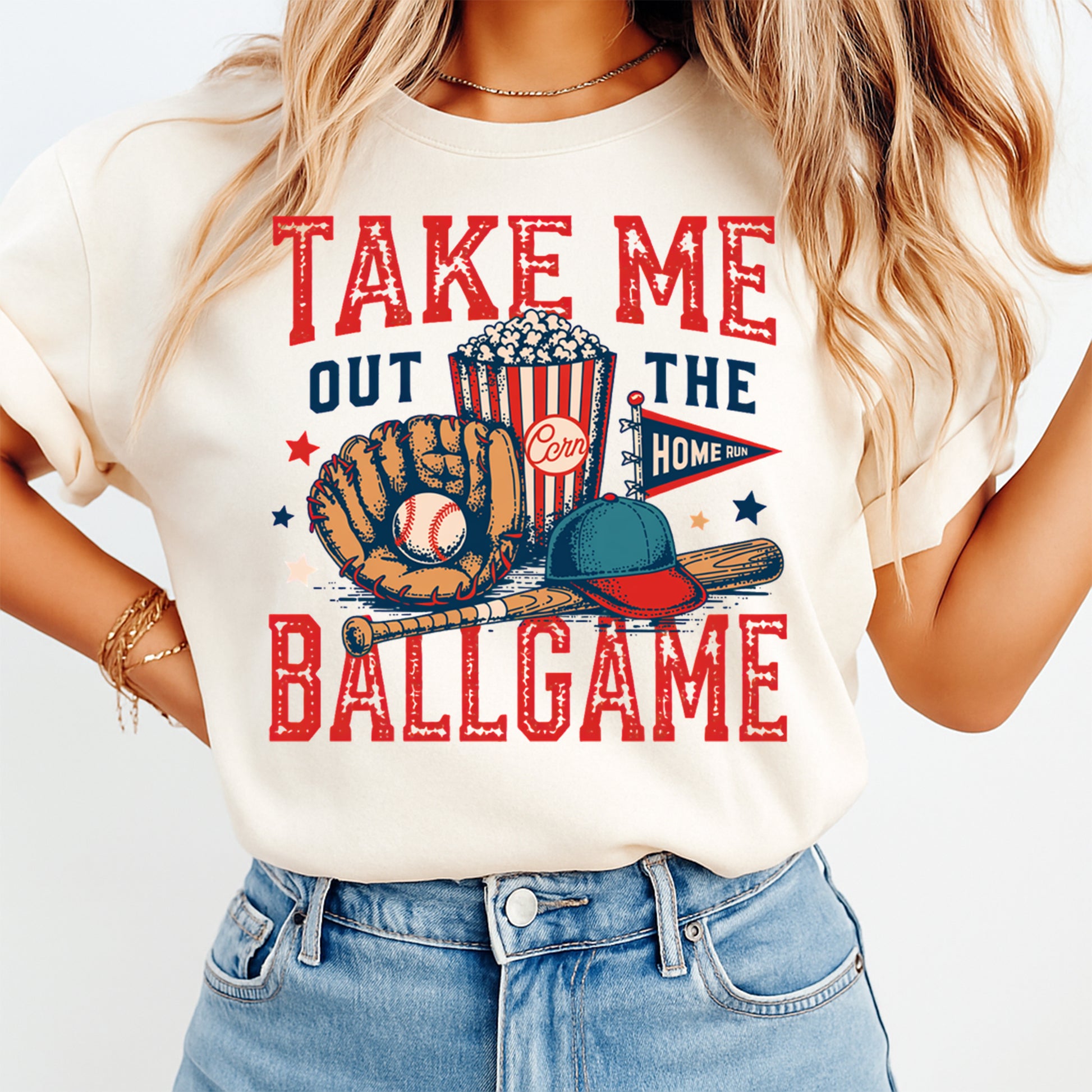Woman wearing a cream shirt with take me out the ballgame ready to press dtf graphic featuring a baseball glove ball bat popcorn and cap