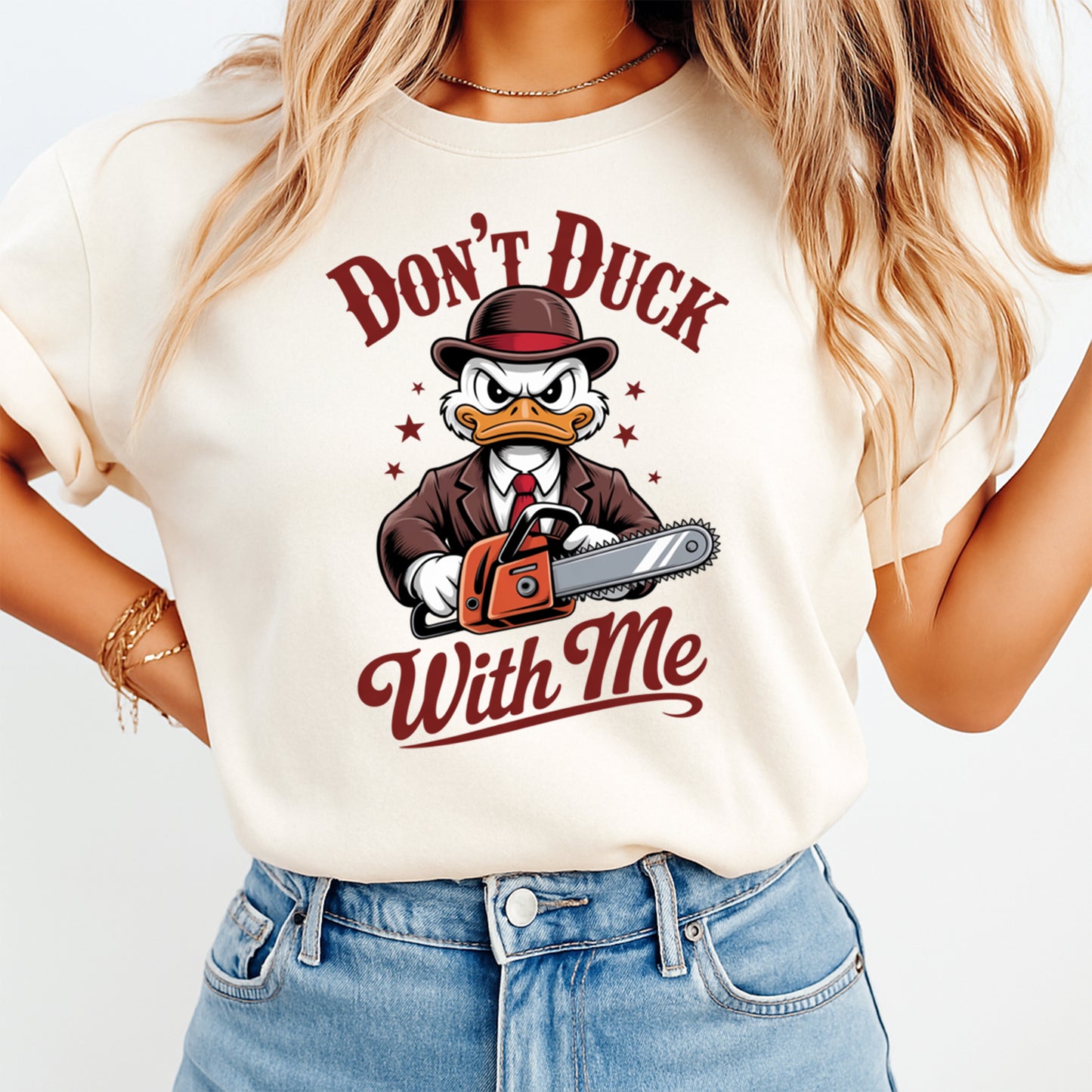Woman wearing a cream shirt with a funny duck ready to press dtf graphic featuring angry duck, chainsaw, and Don’t Duck With Me text