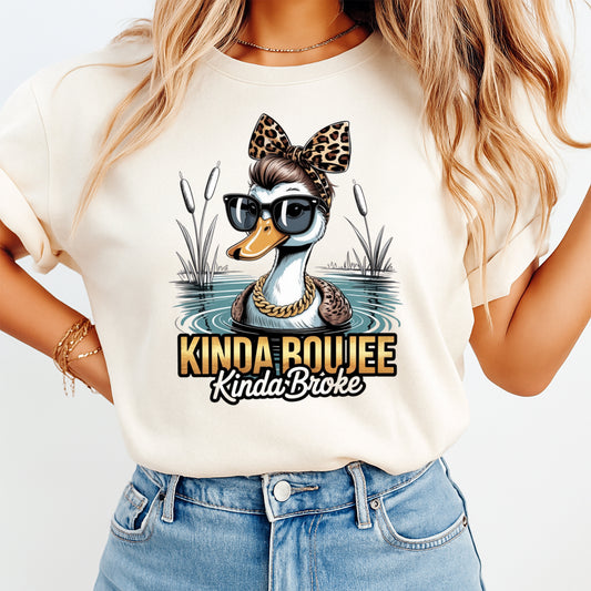 Woman wearing a cream shirt with a funny duck ready to press dtf graphic featuring black sunglasses leopard bow and Kinda Boujee Kinda Broke text