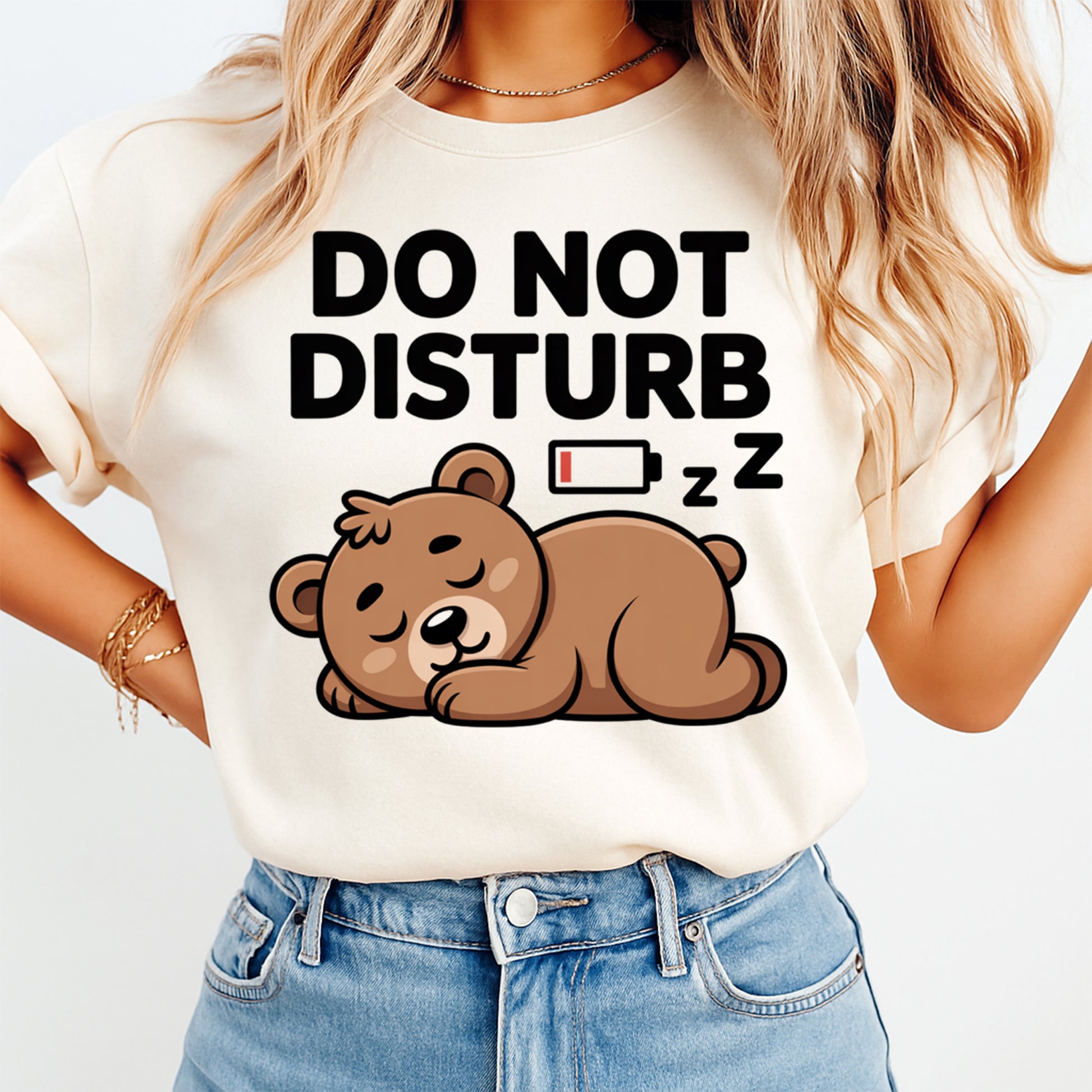 Woman wearing a cream shirt with a cute sleeping bear graphic and do not disturb phrase, ready to press dtf mockup