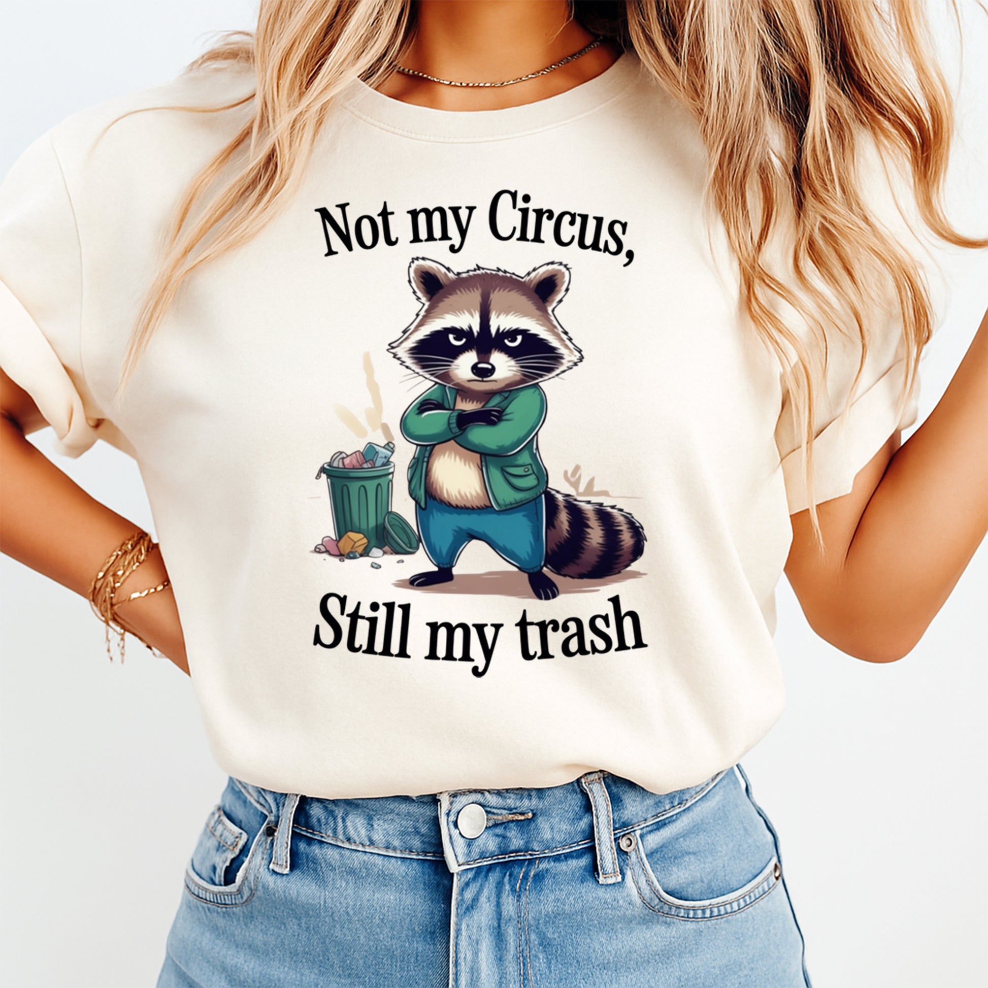 Mockup shirt featuring an angry raccoon beside a tipped trash can with the phrase Not my Circus Still my trash
