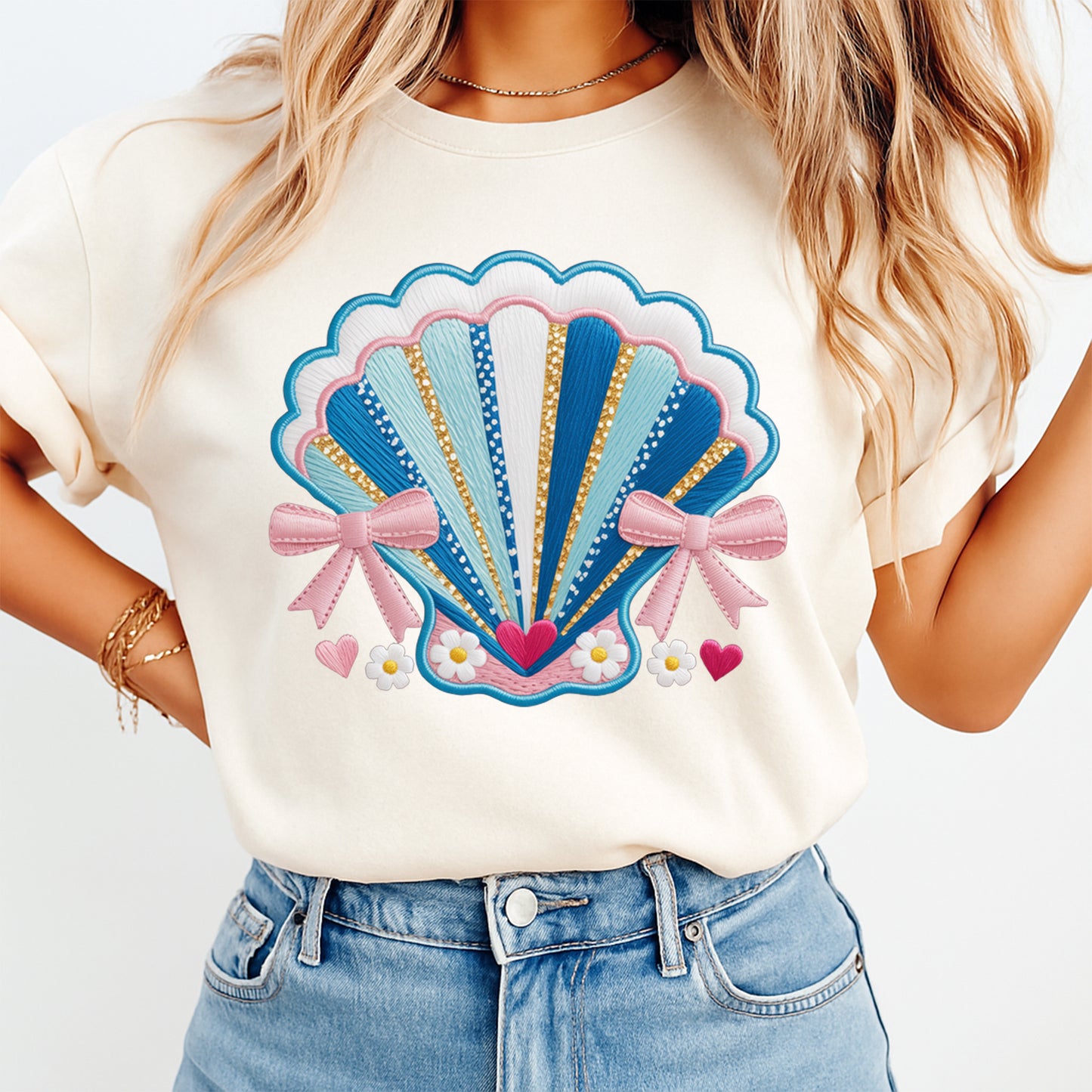 Mockup image of a cream shirt featuring a blue seashell with pink bows, daisies, and hearts in a coastal summer style