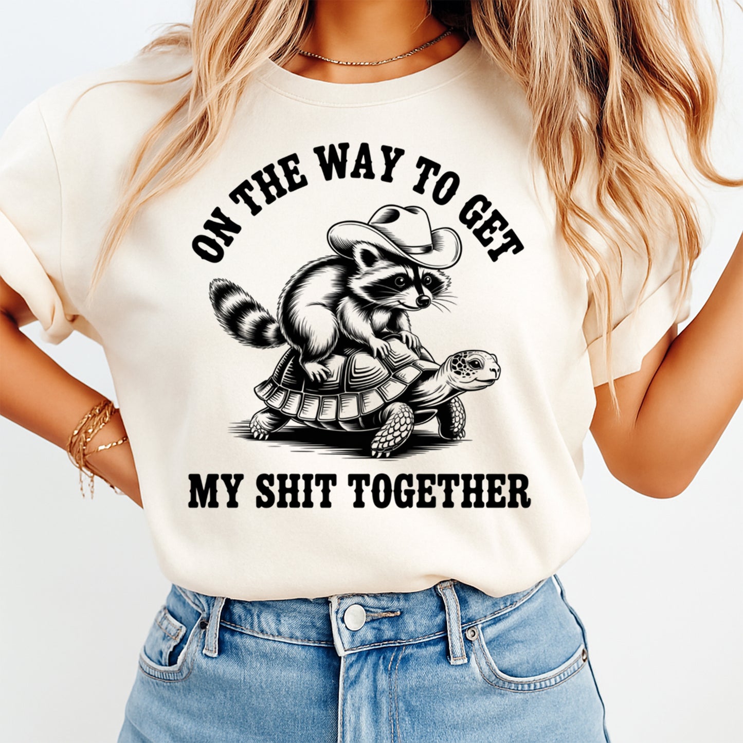 Funny sarcastic ready to press dtf transfer mockup on cream shirt with raccoon in cowboy hat riding a turtle and adult humor quote.