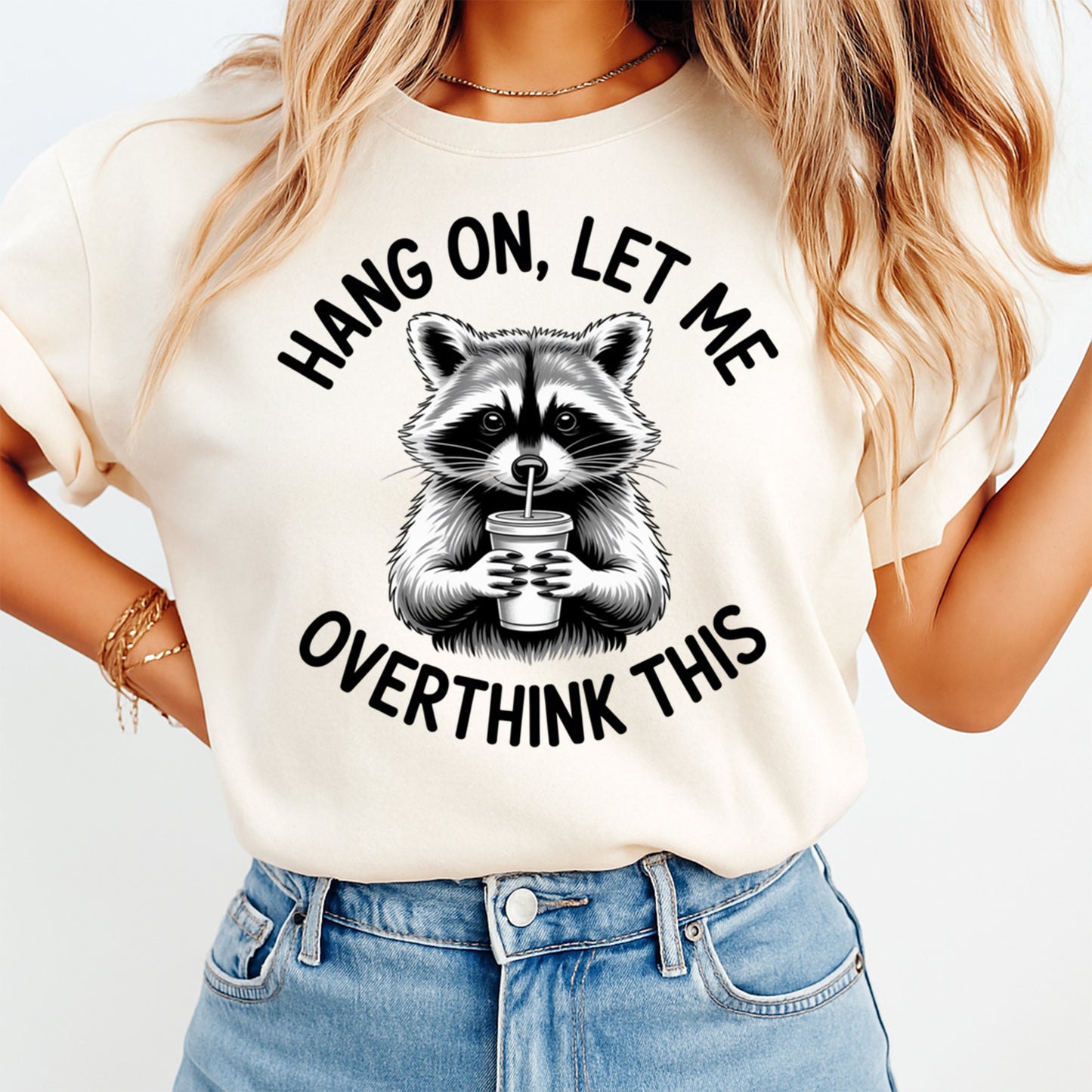 Mockup of funny raccoon ready to press dtf transfer on a cream shirt featuring “Hang On, Let Me Overthink This” quote for DIY funny shirts.