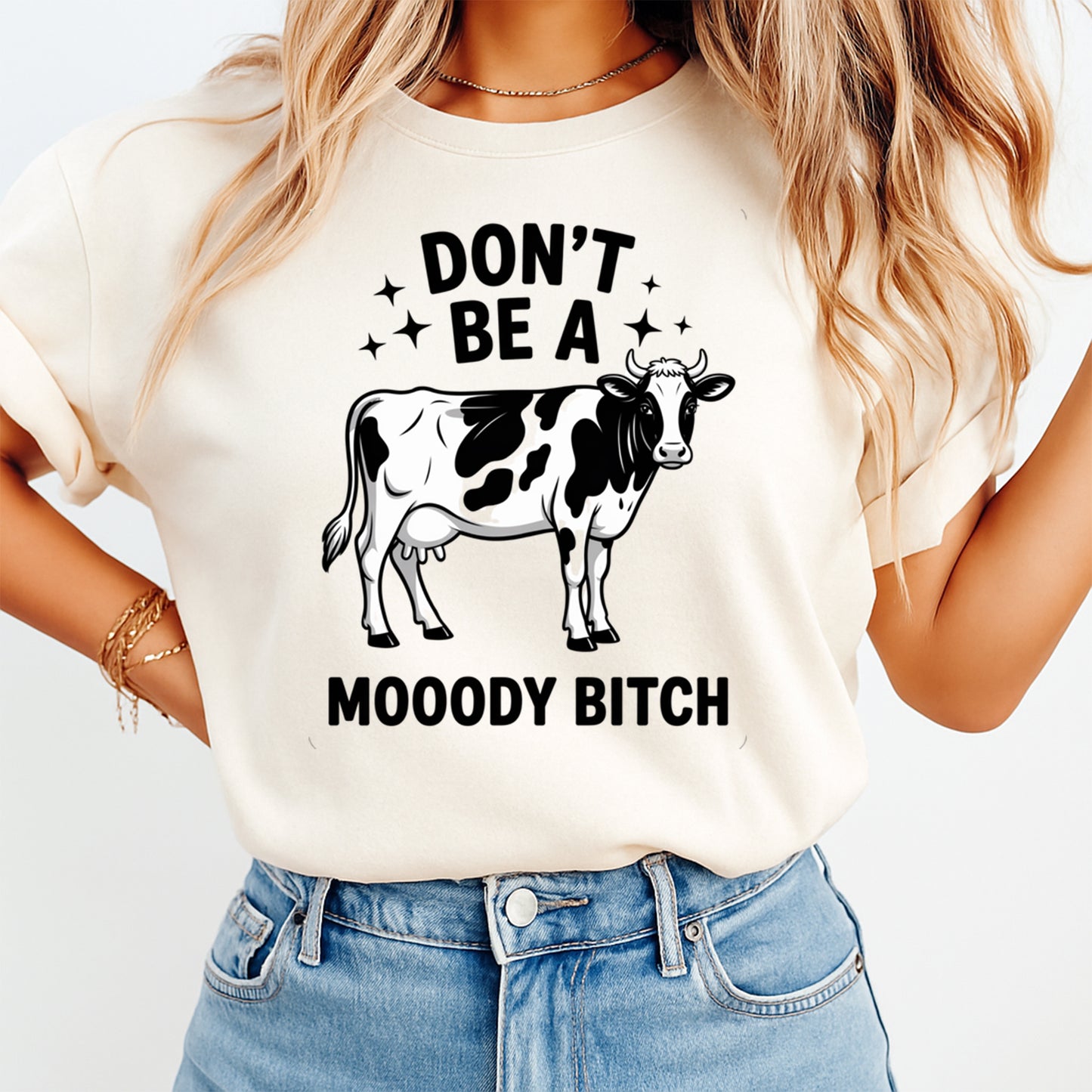 Mockup of funny cow ready to press dtf transfer on a cream shirt featuring “Don’t Be A Mooody Bitch” quote for DIY sarcastic shirts.
