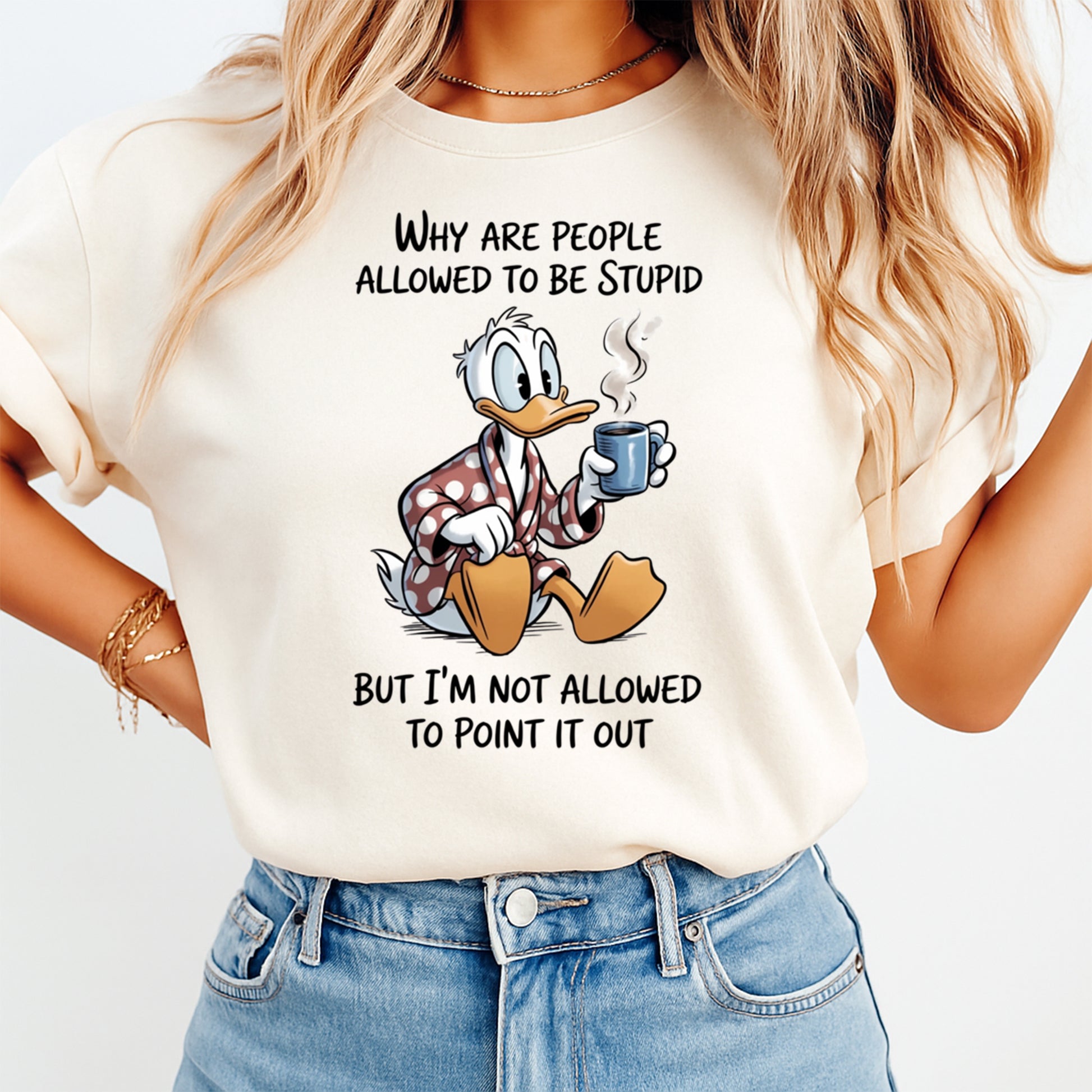 Mockup of a cream shirt featuring a sarcastic duck ready to press dtf transfer with the phrase Why are people allowed to be stupid but I’m not allowed to point it out.