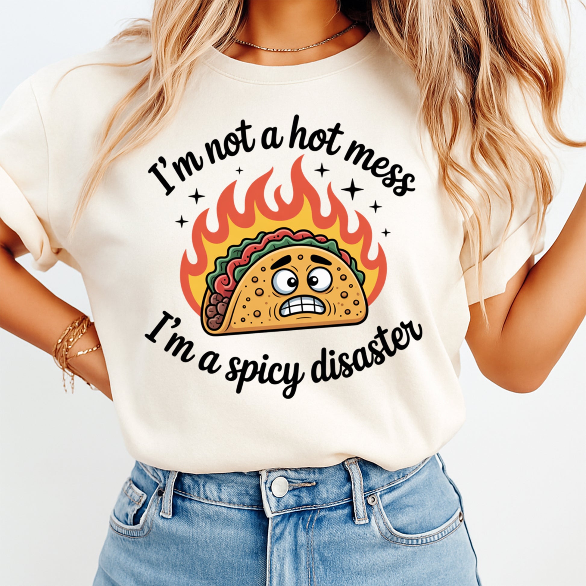 Mockup of a cream shirt featuring a funny taco ready to press dtf transfer with flames and the phrase I’m not a hot mess I’m a spicy disaster.