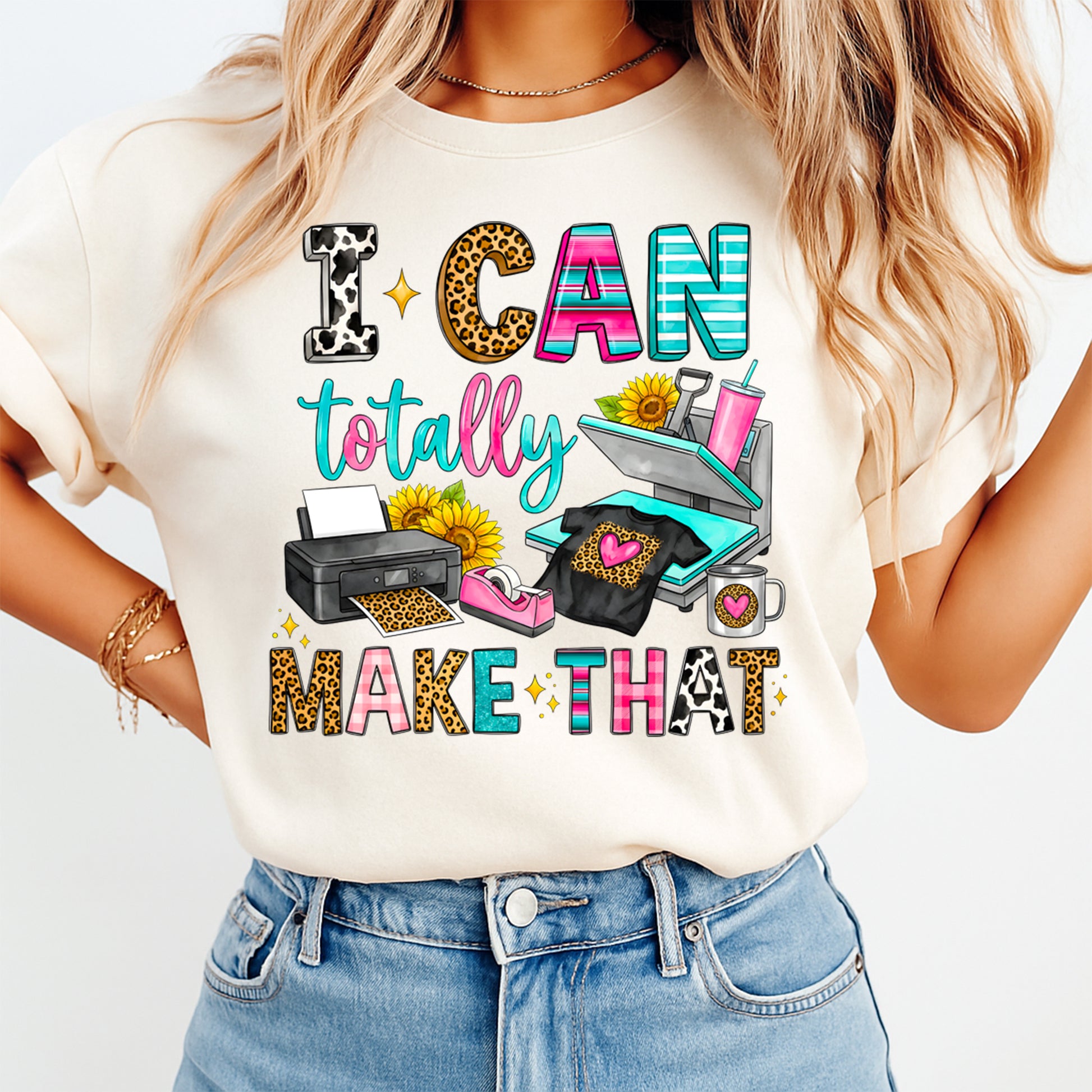 Mockup of a cream shirt featuring a craft maker ready to press dtf transfer with the phrase I Can Totally Make That, colorful patterned letters, heat press, printer, mug, and sunflower details.