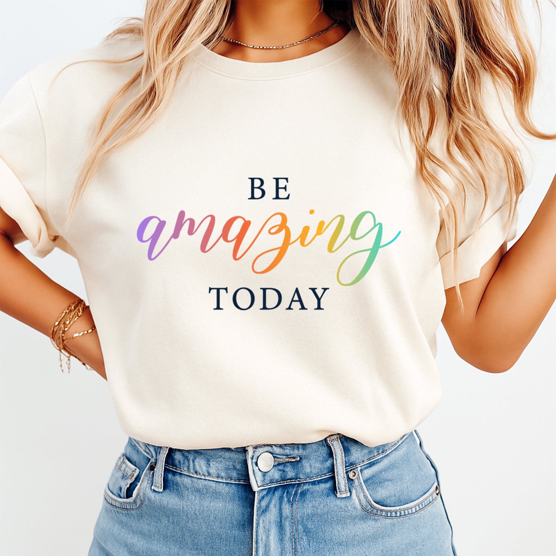 Mockup of a cream shirt featuring an inspirational rainbow ready to press dtf transfer with the phrase Be Amazing Today in colorful script lettering.