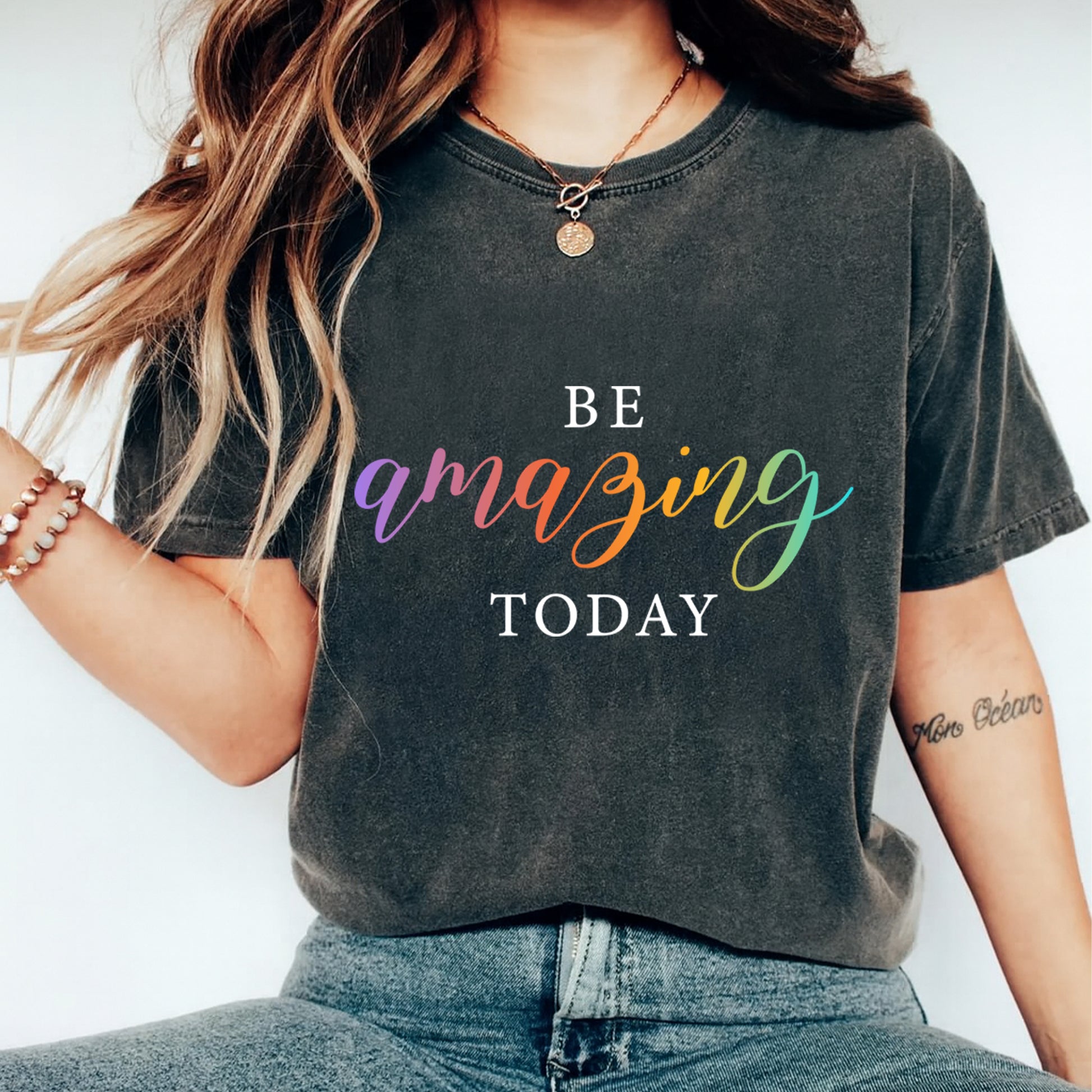 Mockup of a dark shirt featuring an inspirational rainbow ready to press dtf transfer with the phrase Be Amazing Today in colorful script lettering.