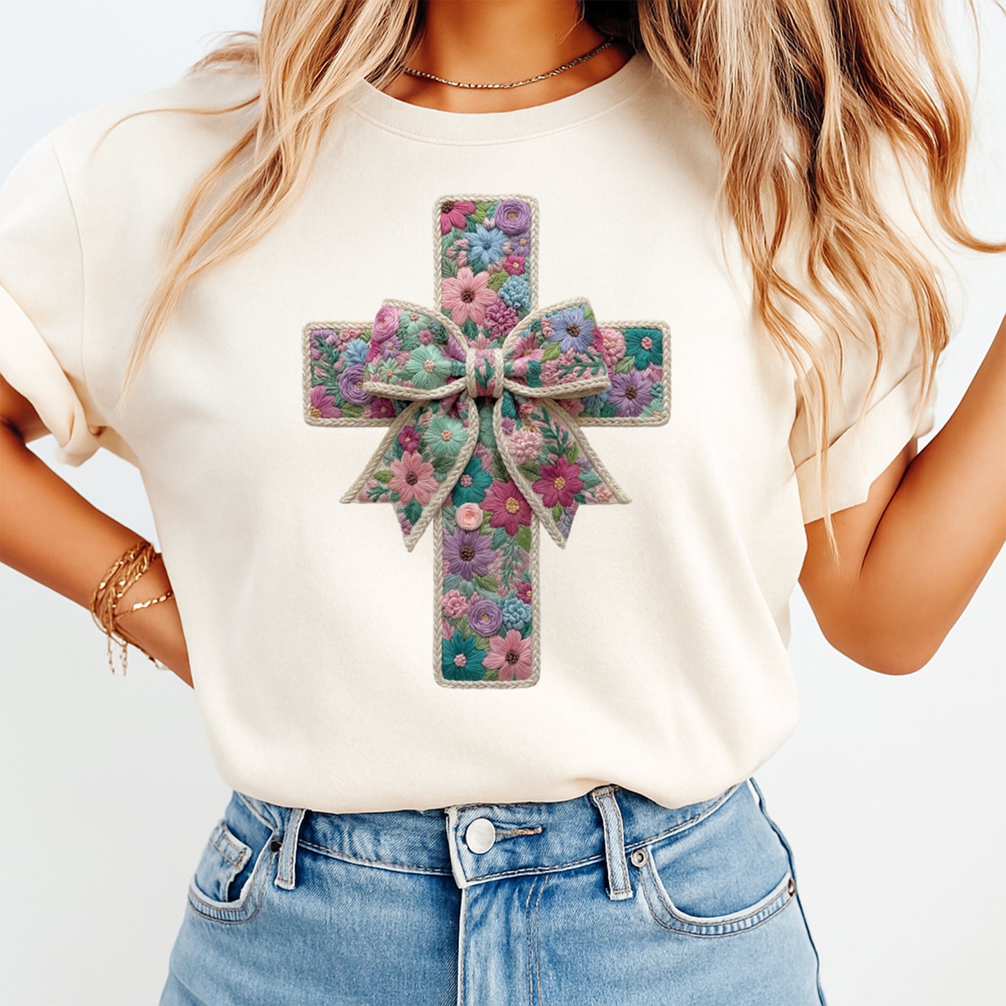 Mockup of a cream shirt featuring a Christian floral cross ready to press dtf transfer with colorful flowers, textured stitching-style details, and a bow accent.