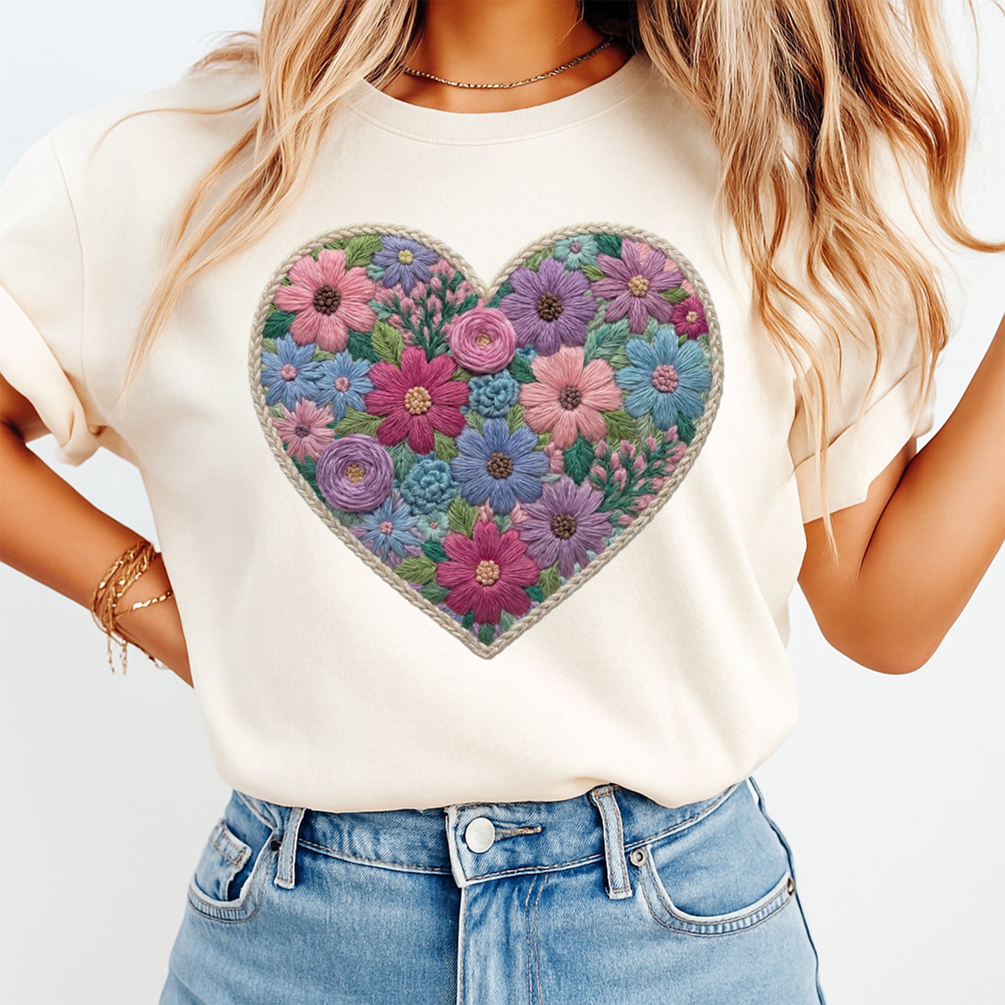 Mockup of a cream shirt featuring a floral heart ready to press dtf transfer with embroidered-style flowers in pink, purple, blue, teal, and green.