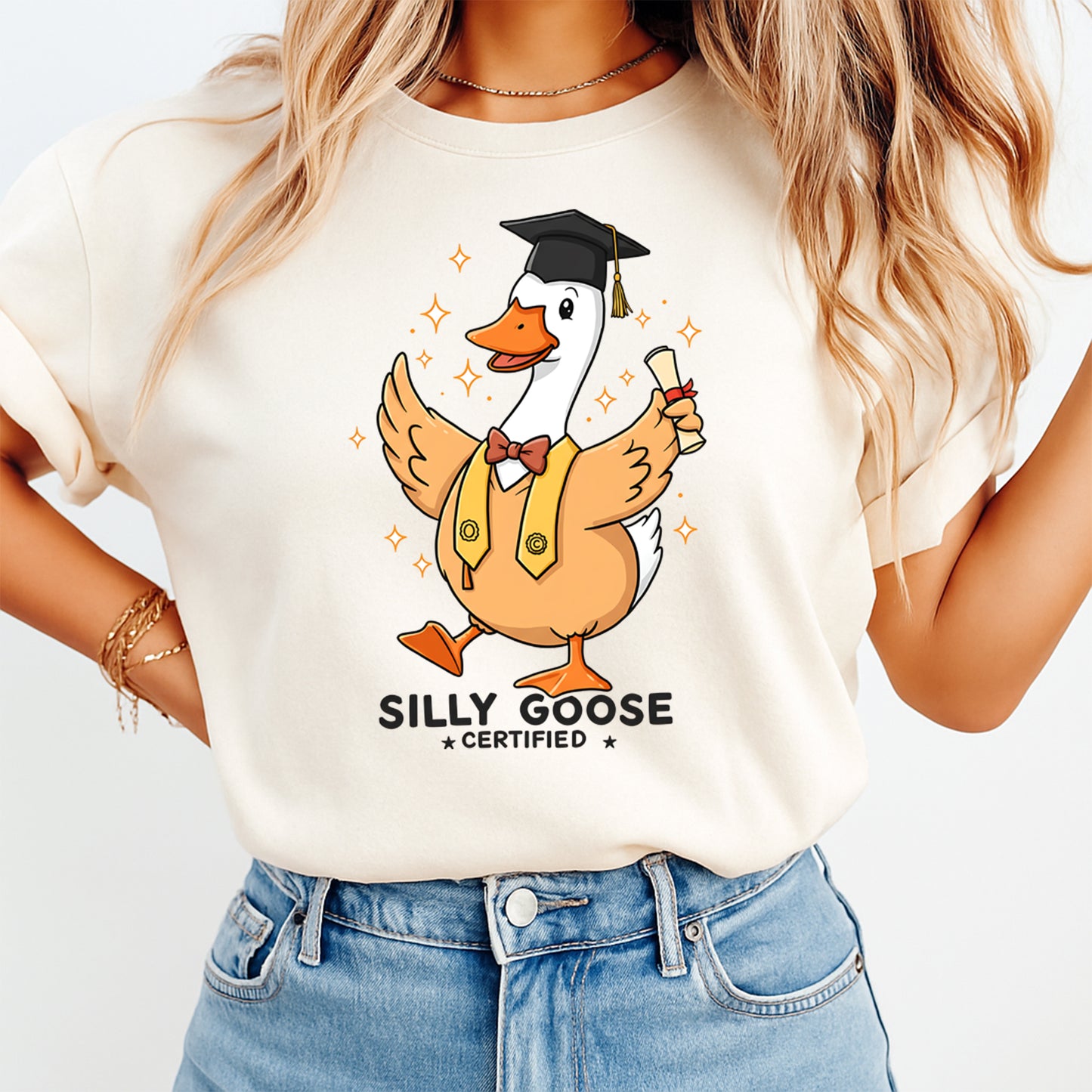 Mockup of a cream shirt featuring a graduation goose ready to press dtf transfer with cap, diploma, vest, bow tie, and the phrase Silly Goose Certified.