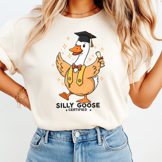 Mockup of a cream shirt featuring a graduation goose ready to press dtf transfer with cap, diploma, vest, bow tie, and the phrase Silly Goose Certified.