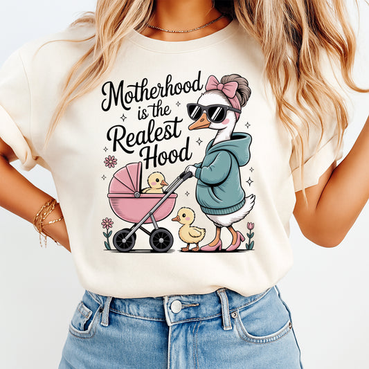 Cream shirt mockup featuring a funny motherhood ready to press dtf transfer with a stylish goose mom pushing a stroller and the phrase Motherhood is the Realest Hood.