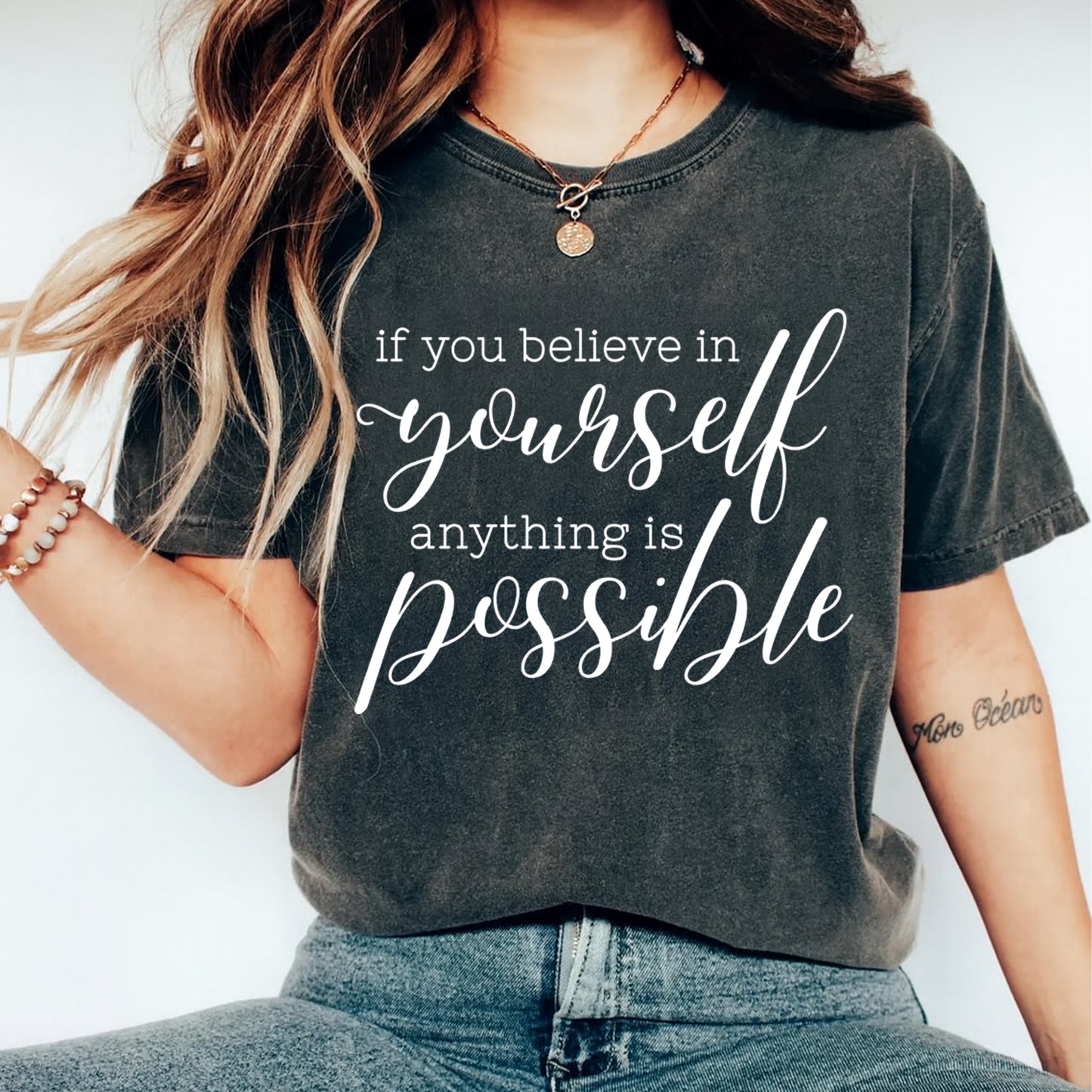 Black shirt mockup featuring an inspirational ready to press dtf transfer with the phrase if you believe in yourself anything is possible in white lettering.