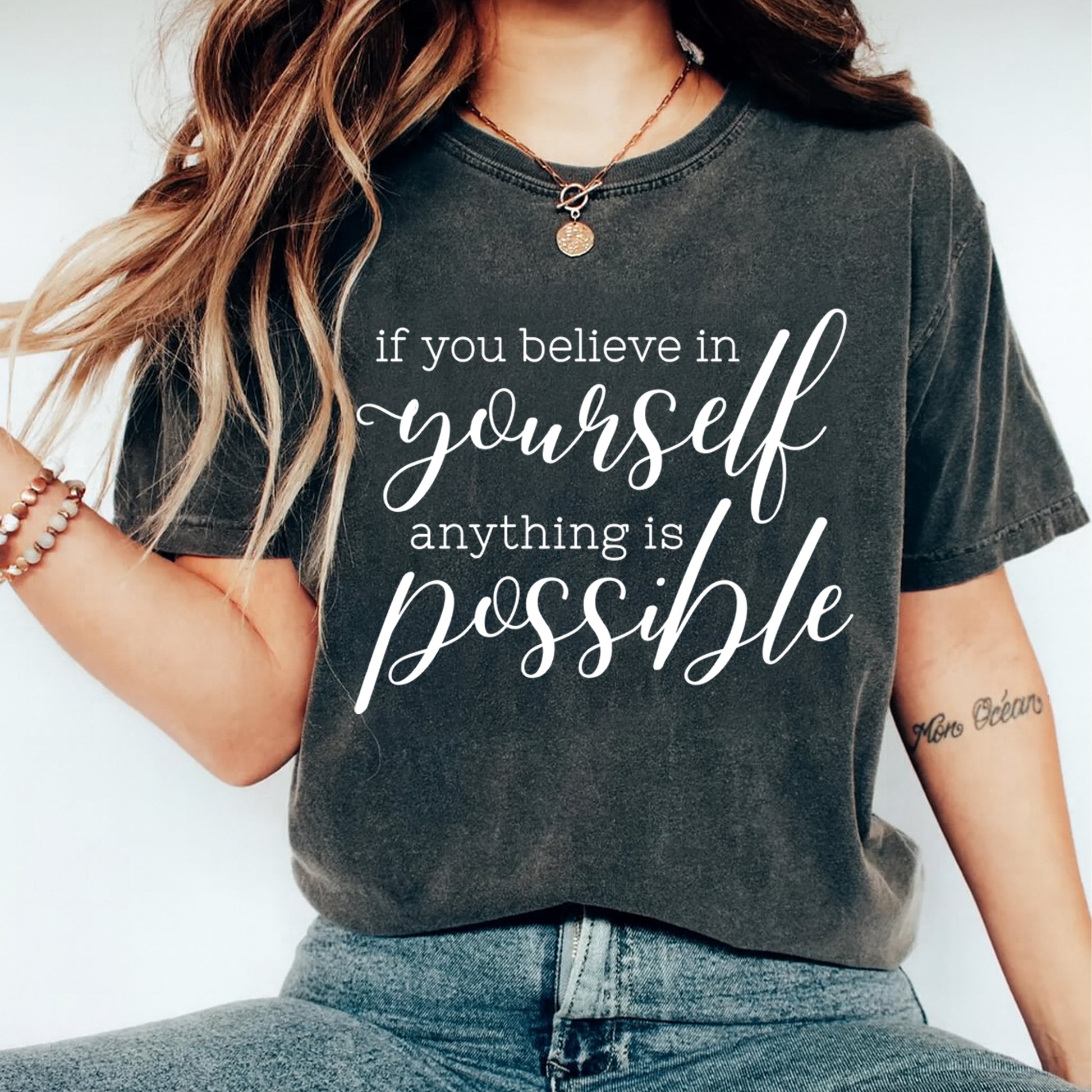 Black shirt mockup featuring an inspirational ready to press dtf transfer with the phrase if you believe in yourself anything is possible in white lettering.